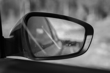 Landscape in the sideview mirror of a speeding car