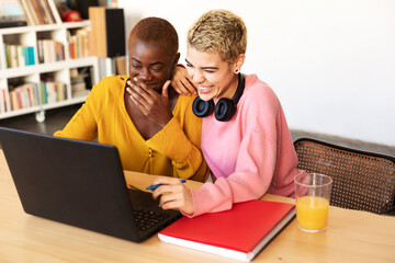 Girls drinking coffee and shopping online on laptop