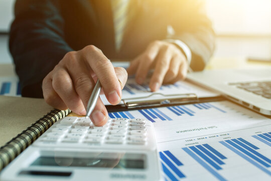 Accounting concept.businesswoman working on desk using calculator for calculate finance report in office
