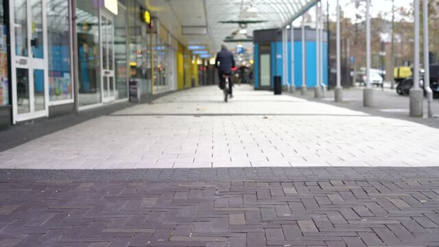 Shot of a old men cycling through empty Tilburg during covid-19 pandemic.