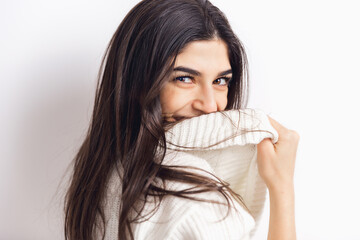 Smiling. Portrait of beautiful brunette woman in comfortable soft longsleeve isolated on white studio background. Home comfort, emotions, facial expression, winter mood concept. Copyspace.