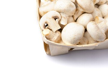 Fresh champignons in a basket isolated on white background.