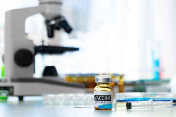 Vaccine in vial for injection on table against background of laboratory