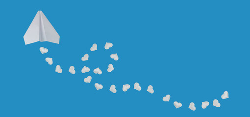 paper airplane and white hearts on blue background. love travel or holiday concept for valentines day. banner, copy space