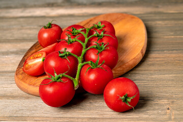 Cherry tomatoes on a branch on a wooden board