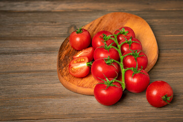 Cherry tomatoes on a branch on a wooden board