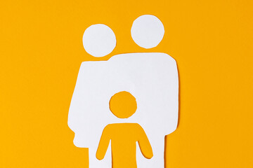White paper family with parents and one child on a yellow background