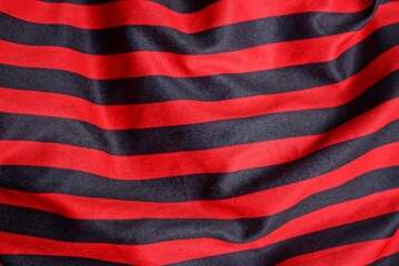Fototapeta premium colored texture of crumpled striped synthetic red black fabric