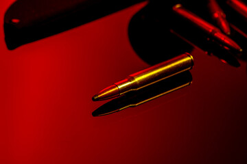 Rifle cartridges on glass background in red light