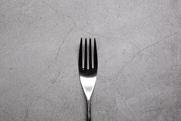 Bright Silver colored fork cutlery isolated on a grey background
