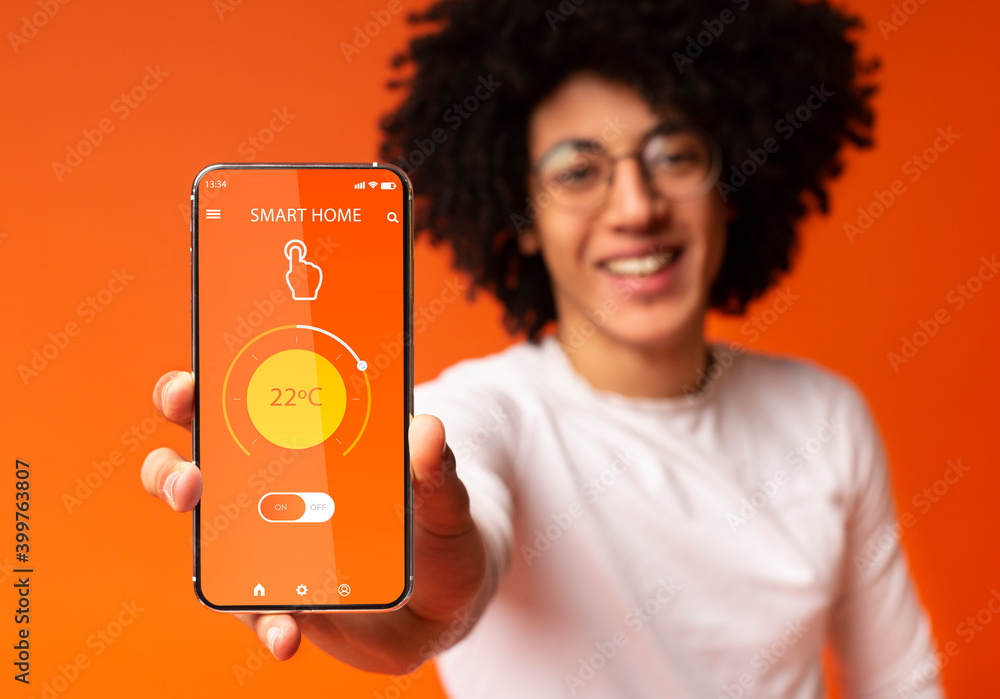 Aufkleber collage with black man showing remote smart home control system on mobile phone screen, orange backg