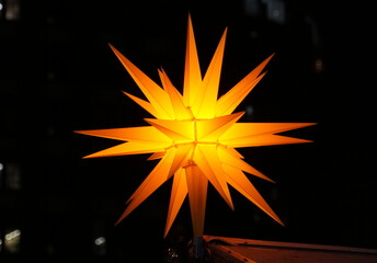A star hanging light in bright yellow color for holiday decorations
