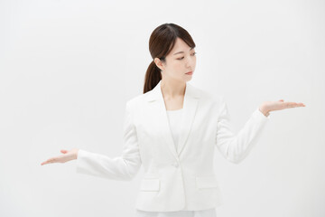 2つの選択肢を比較するようなポーズをするビジネスウーマン
