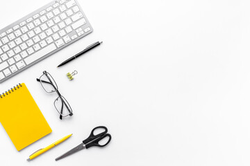 Flat lay office workspace with keyboard and office supplies, top view