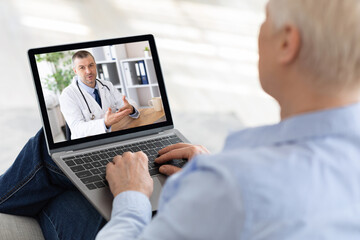 Elderly woman using laptop at home, making video call with doctor, having online conference with medical specialist