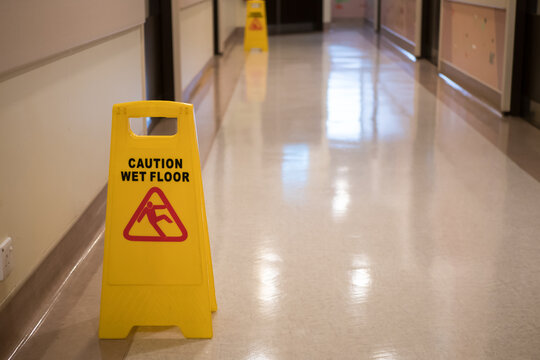 Sign showing warning of caution wet floor in hospital corridor.