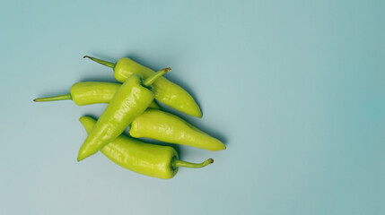 Green sweet peppers on light blue background