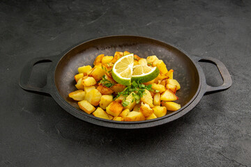 front view tasty fried potatoes inside pan with lemon slices on dark background photo food cuisine meal color