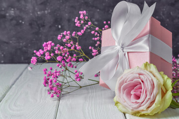 Gift box with flowers on pink Valentine's Day background. Copyspace. Postcard for anniversary, Mother's Day and birthday greetings, there is a copy of the space