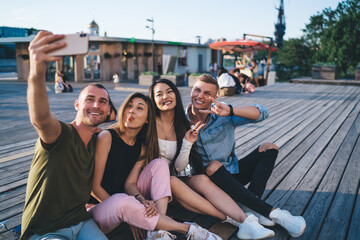 Happy diverse women and men taking funny selfie