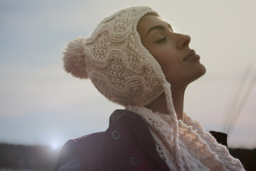 Young woman in a jacket and a hood resting in the autumn forest.