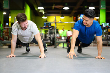 Obraz na płótnie Canvas Two young men doing high planks in gym. High quality photo
