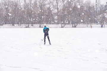 hockey player trains on the rink alone in heavy snow. a person is not visible due to a blizzard