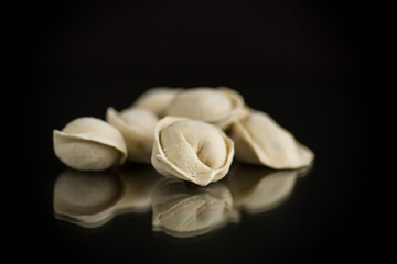 raw homemade dumplings with meat on black background