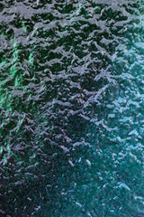 Closeup texture of old blue paint on a concrete wall.