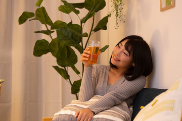 夜の部屋でビールを飲む若い女性