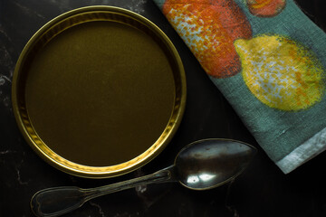 Concept food prop composition with yellow plate and vintage fork on black marble background
