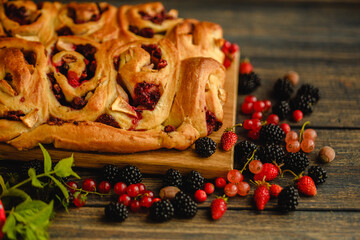 Berry yeast dough pie for tea. Sweet pastries with berry jam. Blackberries, strawberries and currants in dessert. Handmade cake