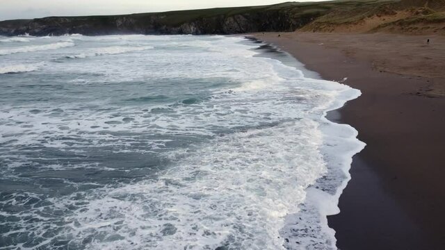 Holywell bay across the waves cornwall England uk aerial drone footage 