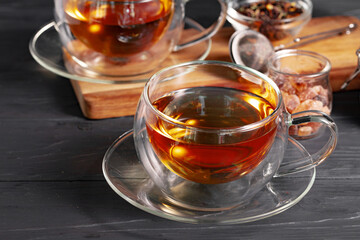 Glass cup of tea on wooden background