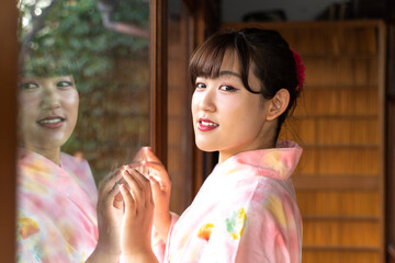 縁側から外を見る浴衣の女性