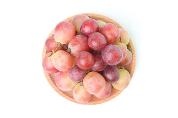 Top view of fresh grape on wooden plate isolated on a white background.