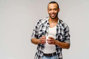 Studio shot of young african american Man having a cup of coffee over light grey background
