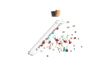 Piles with capsule and test tube. Pill bottle spilling pills on to surface isolated on a white background. Homeopathy.