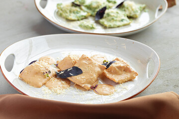 Russian dumplings with parsley and mushroom sauce served in two plates