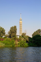 Fototapeta premium Vertical shot of Cairo tower with green trees and river Nile at sunny day