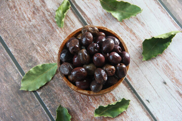 fresh natural black olives in a wooden plate
