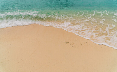 Fototapeta na wymiar Beach sand sea shore with Blue wave and white foamy 