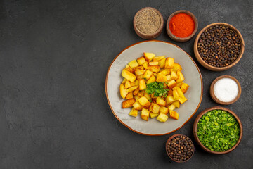 top view tasty fried potatoes inside plate with seasonings on the dark background color food kitchen photo meal