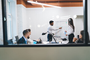 Businessman drawing on flip chart during work meeting