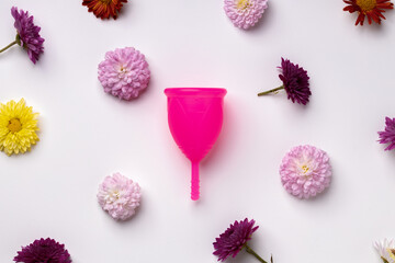 Menstrual cup on floral pattern background top view