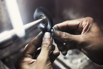 Fototapeta na wymiar Closeup of jeweler hands polishing a ring.