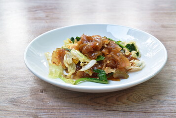 stir fried rice noodles with egg and Chinese kale in black sweet soy sauce on plate