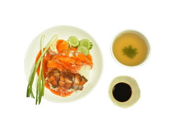 crispy and roasted pork slice topping on plain rice dressing sweet red gravy sauce on plate