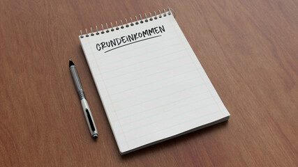 Grundeinkommen Text auf Notizblock auf Schreibtisch