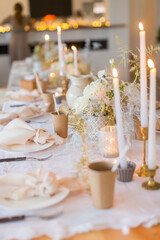 Christmas decoration of the festive table with cakes, glasses and candles